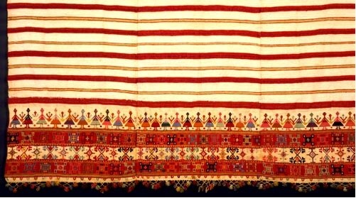 Woven bedspread ornamented with a dense geometric design and the representation of a group dance along the border. From Crete, 19th c. (ΕΕ 3167) image and text copyright Benaki Museum