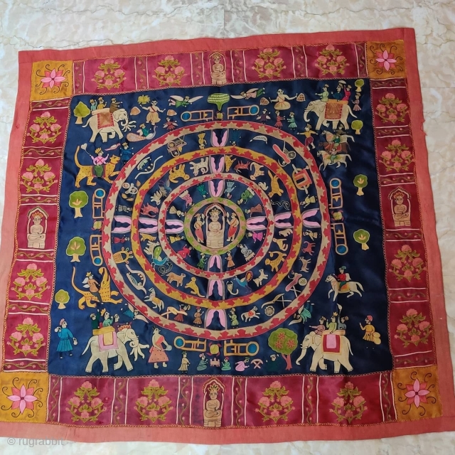 Mochi Embroidery of Jain Samavasarana.

In Jainism, Samavasarana ("Refuge for all") is the divine preaching hall of a Tirthankara represented here by Lord Mahavir.

Surrounding him in concentric circles are heavenly beings, ascetics, nuns,  ...