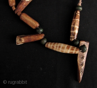 Chin Animal Bone Necklace: Eclectic strand of spherical wood, cylindrical bone and buffalo tooth beads, from the Chin ethnic group in Myanmar. Some of the bone beads have been dyed to resemble  ...