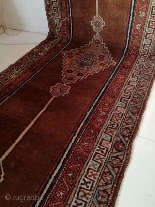 An antique camel hair ground NW Persian runner with 430/108 cm in good condition. Two spots repiled. One side with kilim ending, the other open. On wool rug.     