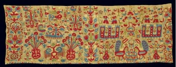 Fragment of an embroidered valance for the adornment of an unknown kind of bridal bed. From Ioannina in Epiros. The diversified scene depicts, in a floral setting, towers and couples, flower vases, peacocks in fountains, and double-headed eagles. 18th c. 1.62x0.57 m. (ΓΕ 6307) image and text copyright Benaki Museum