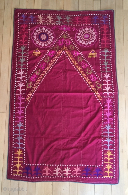 Description and origin: traditional suzani from Uzbekistan, with design of a "mihrab". Silk on cotton. 

Dimensions: approx. 170 x 102 cm

Age: around 1940

Condition: very good. Some wear and tears (see pictures)
  