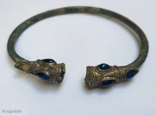 Ancient silver bracelet with lion heads, 2nd-1st century BCE, Near East, inlaid with blue glass, diam. 7.5 cm.               