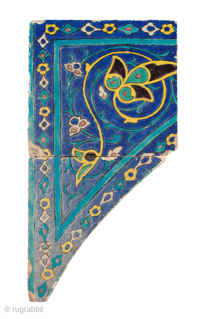 Timurid Cuerda Seca Pottery Tile Spandrel, comprising two tiles, the upper square tile with lower curved triangular tile together forming a design of spiralling yellow tendril terminating in palmettes interlaced with a  ...