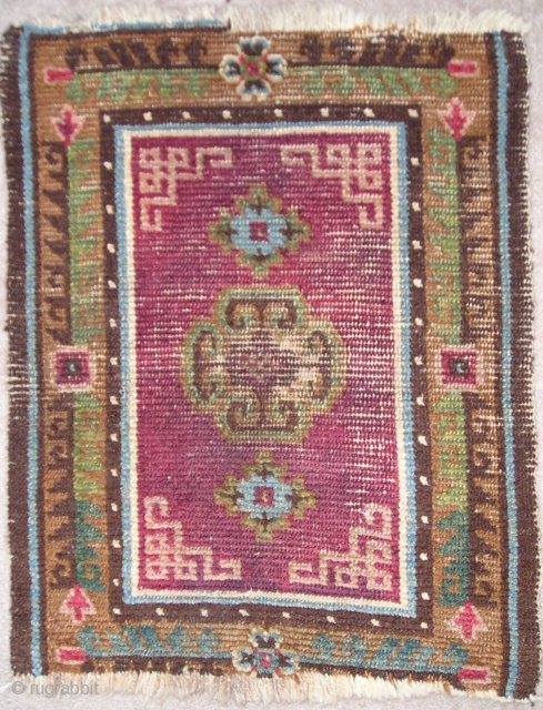 Tibetan saddle top with an insect red or madder ground. Nice ashik-looking quatrefoil medallion and vegetal border. All natural colors. Sometime in the 19th century? (54 x 68 cm)    