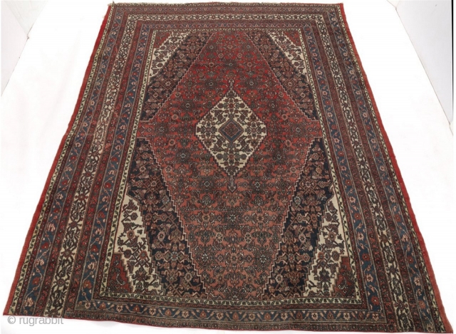 Semi-Antique Persian Dargazin Carpet;

14'8" x 11'6";

Medium low wool pile on cotton weft. Field with central lozenge shape medallion within extensions, stylised floral design on ruby red; corner guards on navy blue, ivory  ...