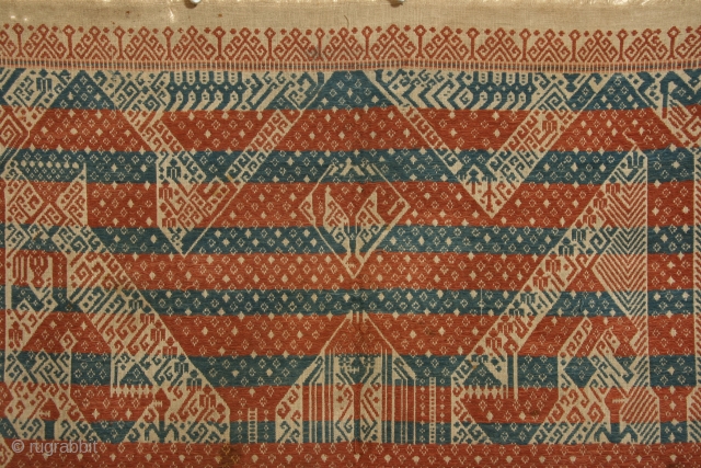 Ceremonial cloth ( tampan), Sumatra, Indonesia, cotton with supplemental weft patterning, 19th century, 27 x 29 inches.
The alternating bands of red and blue that cover the design is quite unusual.   