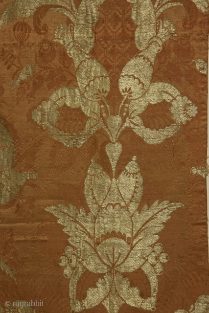 Silk brocade fabric panel with metalic gold thread, of a type now called "bizarre", England or France, circa 1680-1720, 15 x 40 inches, intact selvedge on one long side.Condition very good with  ...