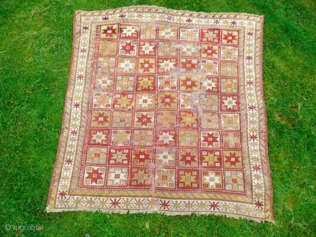 Beautiful mid 19th century Turkish rug. Condition, wear and small holes, but has been carefully repaired and backed, to make it a lovely, usable almost square rug. Size: 7' x 6'.9"  