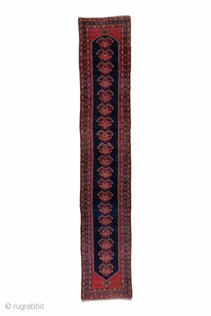 Malayer Runner

3.3 x 16.10
1.00 x 4.90

This as new west Persian runner displays a zig-zag edged navy otherwise plain subfield with 19 leafy palmettes, on a red ground.  The green main border  ...