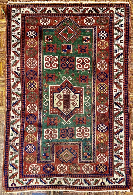 Karagashli Caucasian Prayer Rug; ca 1875;  4’2” x 6’3” / 127 x 190 cm.
Rich emerald green reentrant field with a concentric 8-sided medallion arrangement 
and symmetrical pairs of hooked squares in  ...