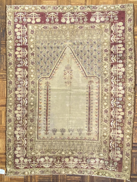 Turkish Panderma prayer rug, ca. 1850;  4ft. x 6ft. / 140 x 186 cm.

Pale-olive, multi-faceted mihrab, with a floral “mosque lamp”, two floral columns,
and four flowering shrubs; at the spandrels, a  ...