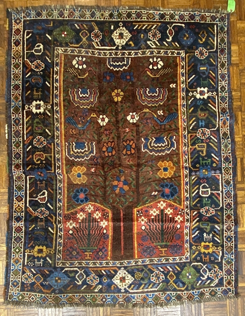 S.W. Per-zian  rug, 4’10” x 6’4” / 147 x 193 cm.

Mahogany brown field adorned with a flowering tree with whimsical 

birds and generously proportioned blossoms. Two reserves in red, to 

the  ...