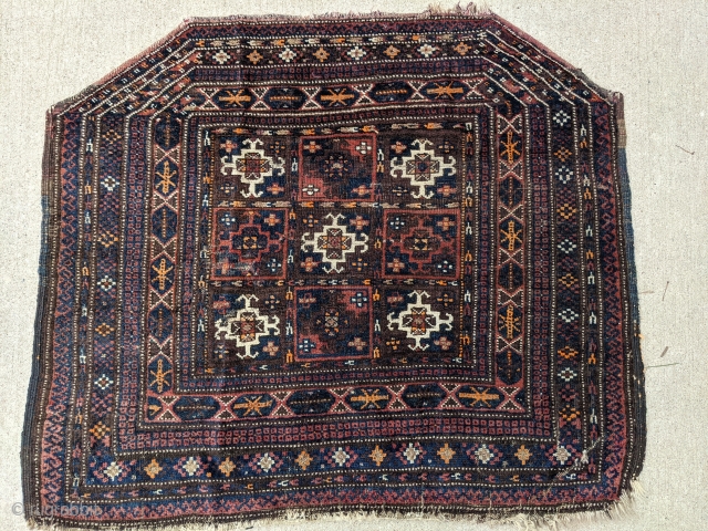 Old Baluch saddle cover. 2'10" x 3'5". Small silk highlights, overall good pile. Original sides except the bottom right corner. One small area of moth damage photographed.

Cheers.      