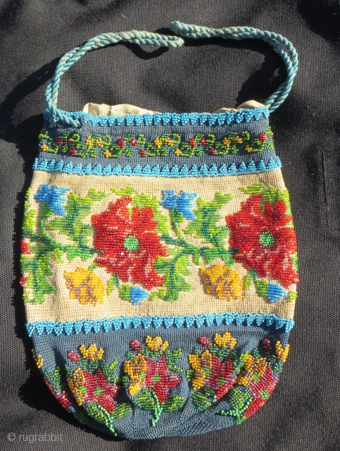 Exquisite micro beading to this purse made over 100 years ago, probably in France.Tiny beads, arranged to depict a wonderful assortment of flowers: roses, pansies, marigolds and Morning Glory in a broad  ...