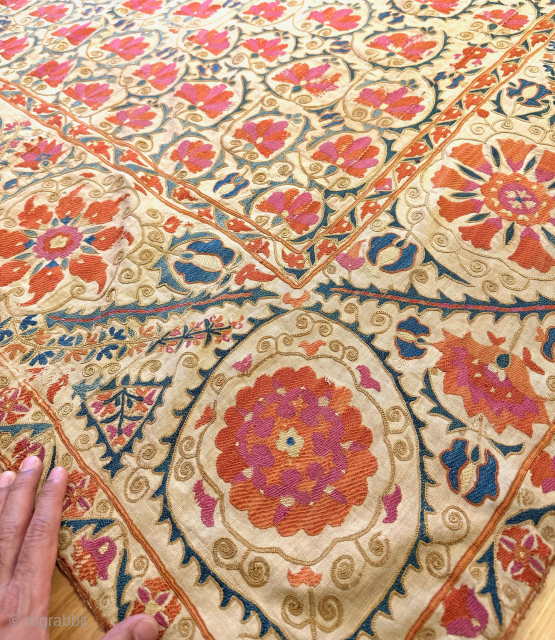 A stunning mid-19th century Antique Uzbek Bukhara Suzani, showcasing exceptionally fine silk embroidery on a linen Karbos ground. This large-scale masterpiece features chain-stitched and basma/flat stitch techniques. The vibrant field design displays  ...