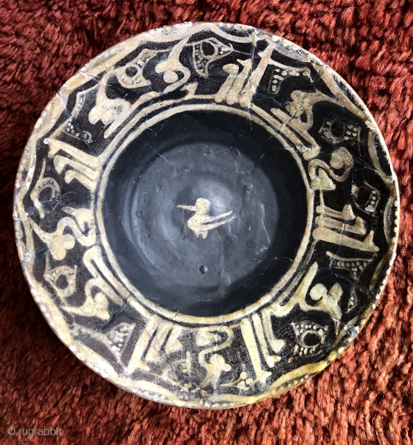 Nishapur Ceramic bowl.  North East Iran, 10th century. Size: 8 x 2.5 inches (20.5cm x 6cm) Stylized bird design in center with Kufic inscription band on rim and sparse, simple decoration  ...