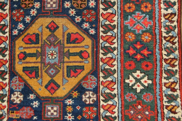 19th century Kurdish runner with a lovely abrashed emerald green border and regular repeat yellow and red medallions on a midnight blue field. New sidecords applied and minor touches of repiling. 3'2"  ...