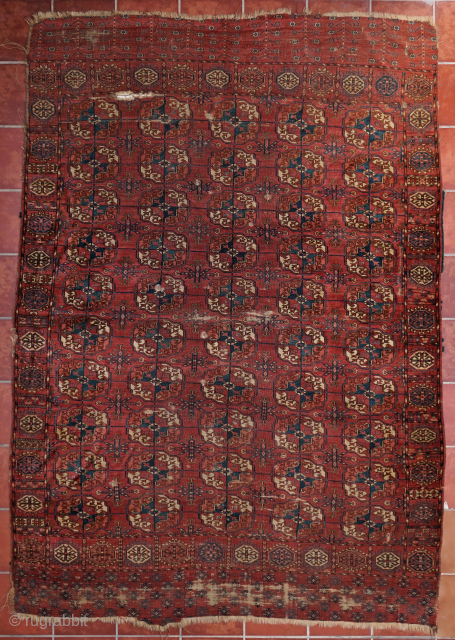 Early Tekke Main Carpet. with areas of wear, holes and a cut. 294cm x 206cm                  