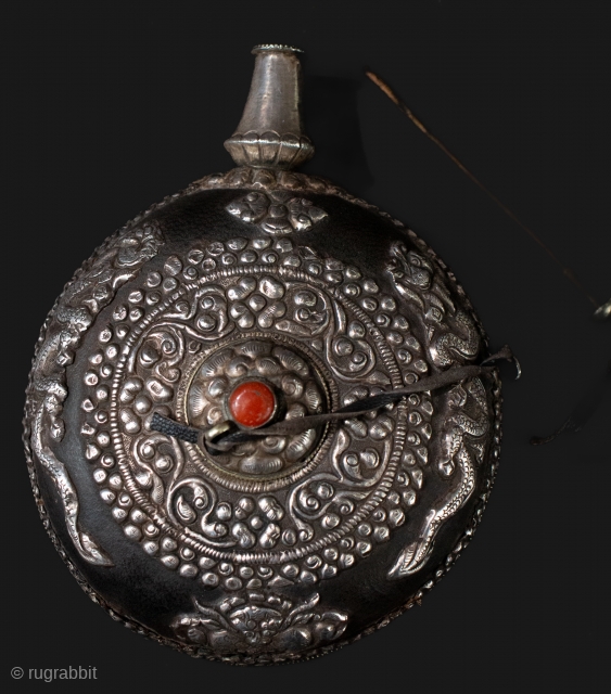   Really nice antique Tibetan snuff with high grade silver and coral center. Makara and dragons in silver framing the central foliate designs. Ebonized wood surface with leather attached to the  ...