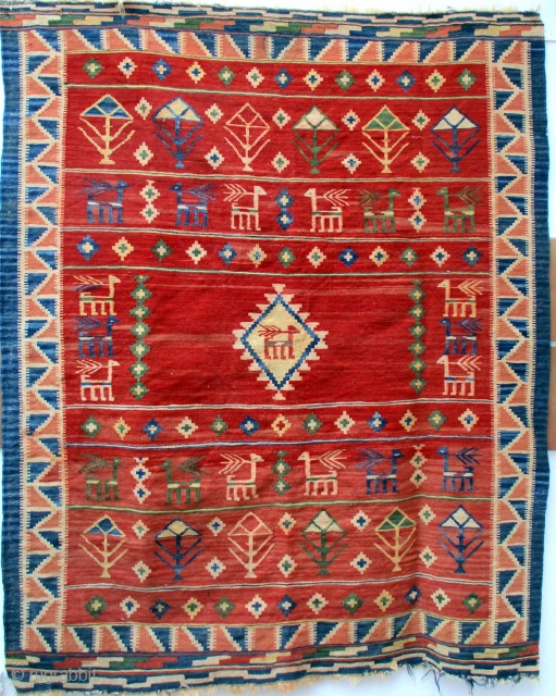 OLD FARS KILIM containing the typical designs woven by rural weavers of repeated flower heads, bushes and shrubs seen from the sides and animals which are probably goats. The weaving is very  ...