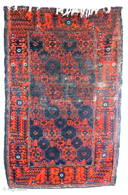 ANTIQUE BALOUCH/BELOUCH RUG from north east Persia, 1920s. There is a band of wear about 30 centimetres /12 inches) across the top half of the field. The rest of the piled centre  ...