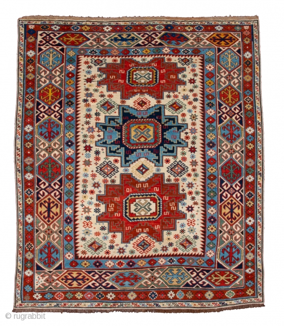 Caucasian Kuba Rug The white field contains three Lesghi stars, alternately in shades of blue and red, which are surrounded by a multitude of small hooked diamonds, stars, crosses and blossoms. The  ...