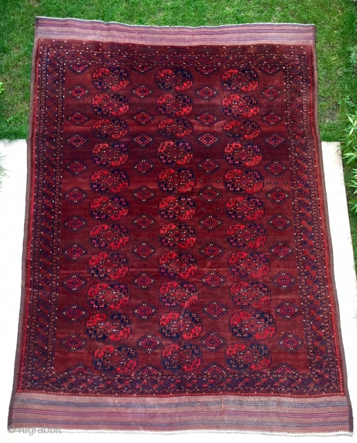 Description and origin: antique Ersari carpet, from Turkmenistan. A soft red ground with three columns of eleven large Guls surrounded by a narrow angular border. Excellent pile with slight surface mark, attractive  ...