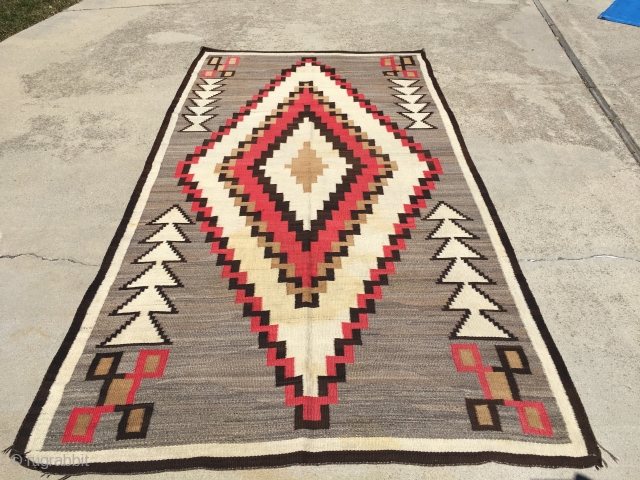 Nice old Navajo measuring 5'x 9'5" with 6 warps and 12 wefts per square inch with slight yellow stains in the ivory part of the medallion, lower half, with one side being  ...