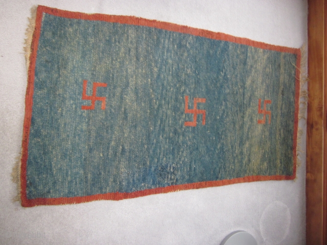 Tibetan, small khden with three eccentric swastikas, abrashed indigo ground, some repair to field,, before 1900                 