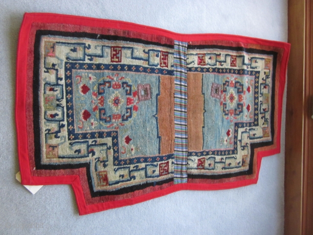 Tibetan notched saddle bottom, relatively uncrowded design on abrashed light blue field. Improvised border with small swastikas. Village product c.1930, very good condition. POR         