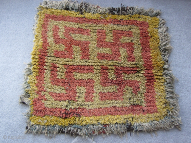 Tibetan: Four swastika wangden monastic meditation mat. Pre-1900, perhaps earlier. Note striped warping at rear of piece---significance unclear               