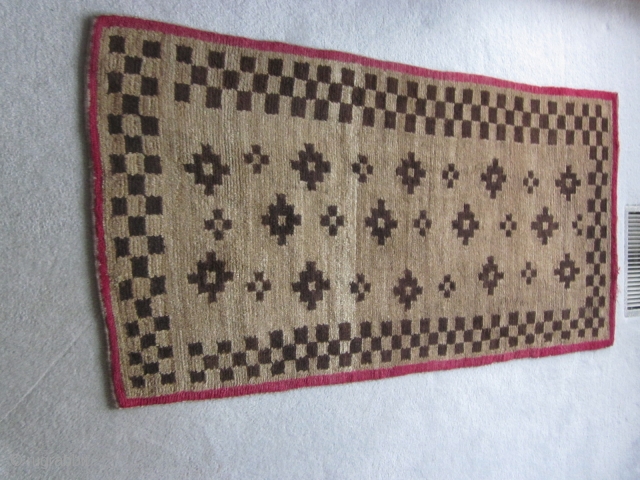 Tibetan khaden, geometric design in browns, with red border. About 3 by 5 ft. c.1930                  