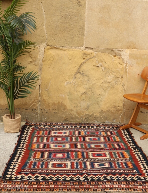 A squarish Qashqai kilim with square motifs! All natural dyes, including a nice emerald green and deep blue. You can buy this kilim directly from our web: https://nomada.biz/en/producto/semi-antique-qashqai-kilim-from-iran-145x129-cms/     