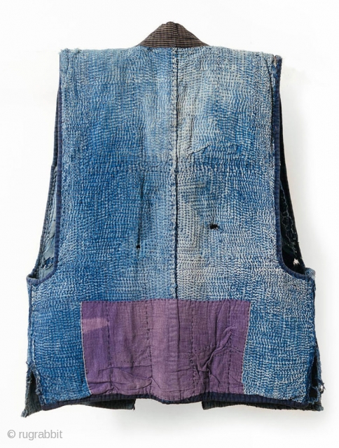 This is a boro sashiko sodenashi, a type of sleeveless hanten, or jacket, typically worn by Japanese farmers. 

The outer fabrics are comprised of solid indigo cotton. A kasuri yoke and lapel  ...