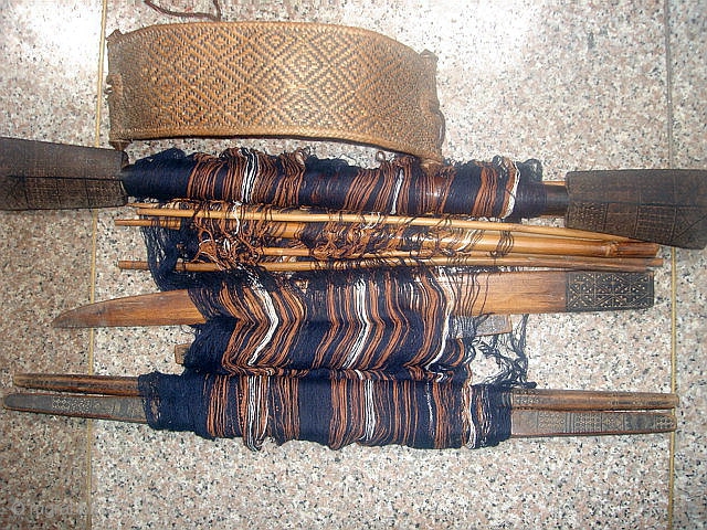 Mei-Fu Li minority, Hainan Island, South China.  Back-strap weaving loom with carved wood and bamboo components that show ancient totems and symbols.---Back-strap from woven rattan.---Cotton warp and partial weft intact.---Oldest carved  ...