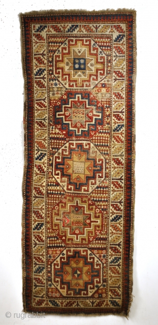 Kazak, Moghan area, 1880's. 
Five octagons with Memling Guls and stars of Salomon. 
Zoroastic Shamdan Mashaal borders with white ground. 
And granulated borders. 
Corroding in the black color. 
worn with old repairs.  ...