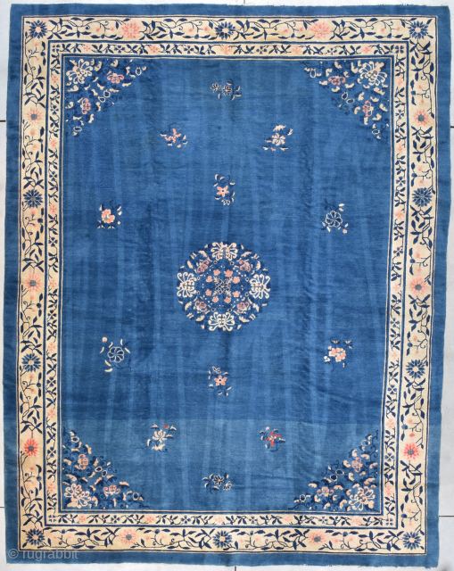 This circa 1890 Peking Chinese Oriental Rug measures 9’1” X 11’7” (277 x 356 cm). The rug has a wonderful dark blue ground covered with 12 sprigs of flowers beautifully arranged around  ...