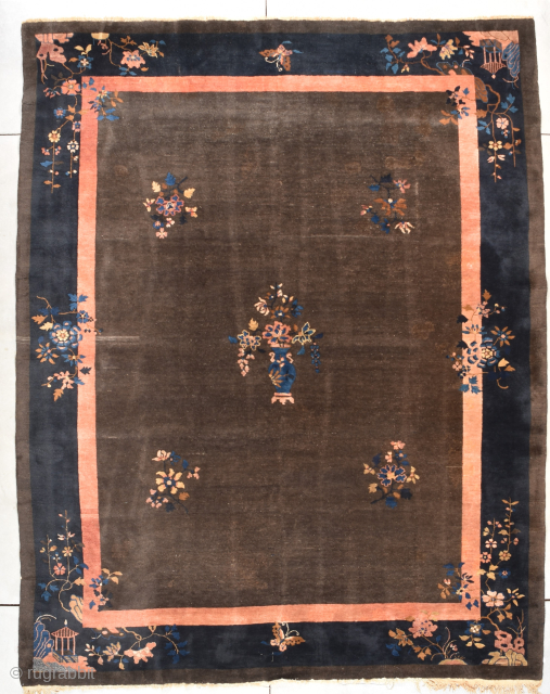 This circa 1900 antique Peking Chinese rug measures 9’0” X 11’5”. It has a deep chocolate brown field with five multi-colored flower sprays in the field, one of which is a beautiful  ...