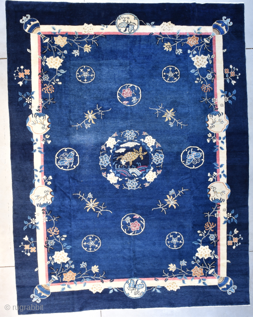 This circa 1900 Peking Chinese Oriental Rug  measures 9‘3“ x 12‘0“. It has a medium blue field surrounded by a dark blue border. The motif and the field contain eight circles  ...