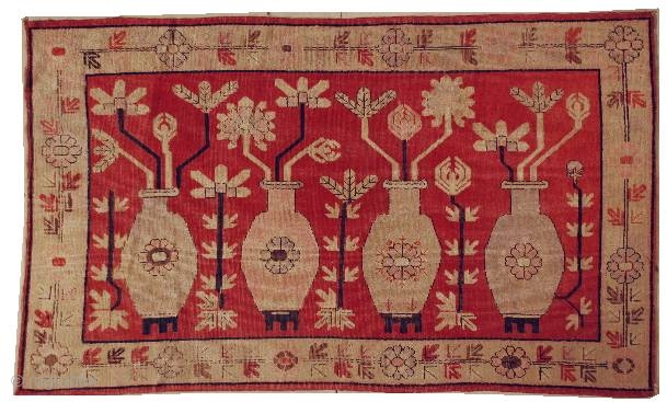 This circa 1920 Khotan antique carpet #6203 measures 4’11” x 8’1”. It has four standing urns in pink and green on a red ground with flowers sprouting from each. It has a  ...