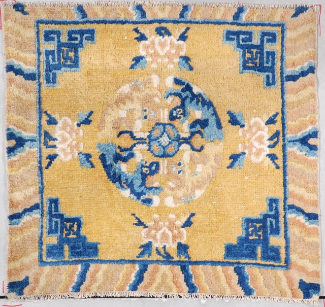 This circa 1860 Ningxia meditation mat (INV 7287) measures 2’1” xX 2’2” (64 x 67cm). It has a mustard ground with Chinese fretwork in blue in the corners. The border has a  ...