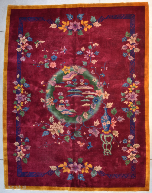 This circa 1925 Art Deco Chinese Oriental rug #8212 measures 9’0” X 11’7”. It has a deep ruby red field containing a green wreath as a center medallion filled with flowers in  ...