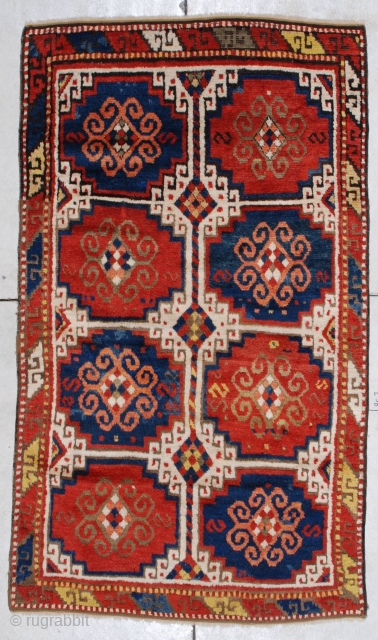 This circa 1875 Caucasian Kazak rug #7283 measures 3’9” X 6’6”. It has the Mogan motif in red and blue with ivory negative spaces. It has one narrow border with the lazy  ...
