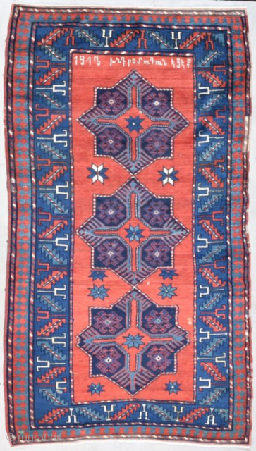 This Armenian Kazak antique Caucasian Oriental rug dated 1913 measures 3’9” X 6’8” has a red ground with an an inscription and three 8 pointed stars running up the field displaying a  ...