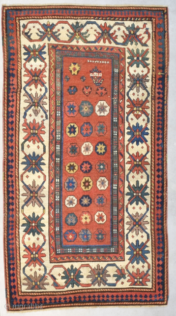 This circa 1880 Kazak Rug #8203 measures 3‘6“ by 6‘5“. It is a so-called ‘Star Kazak’. It has a red ground with nine small white crosses at the bottom of it and  ...