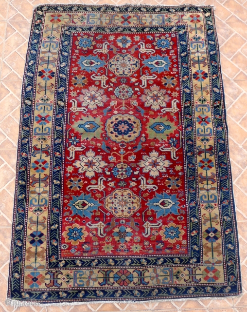 An Afshan Kuba Rug, 4.6ft x 3.2ft.  Circa 1910. The classic design with rows of triple rosettes spread across a burgundy red field.
Each rosette framed by a double latch-hook. A very  ...