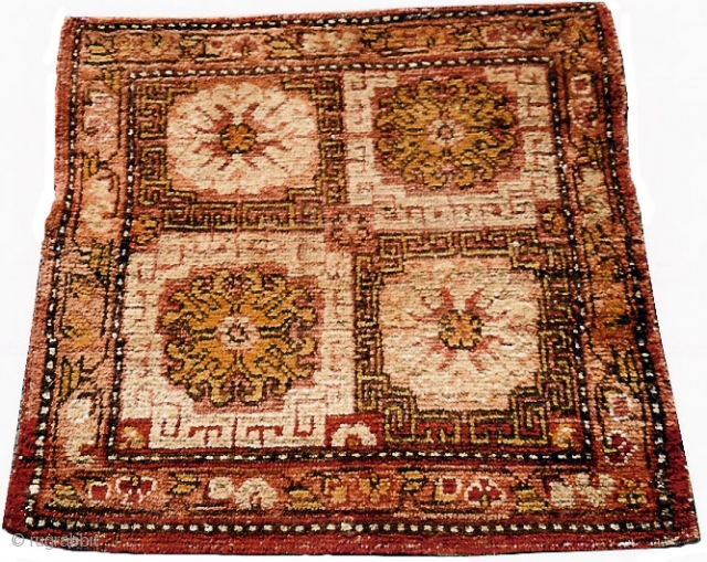 Khotan or Aksu Seatcover 			18th c.			5364
2' 7" x 2' 6"

Four coffered guls with typical Khotan borders.

Structure: Wool pile on cotton foundation.

Condition: Losses to ends.  Repiling of a few rows of knots  ...