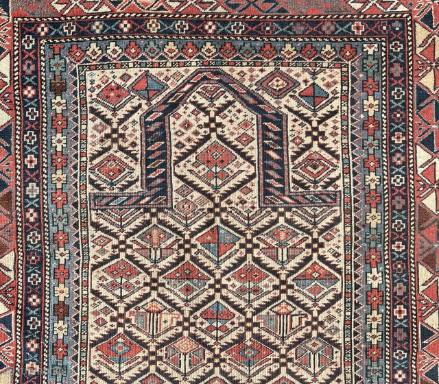 Shirvan prayer rug
This East Caucasian prayer rug shows a characteristic diamond lattice design of dark blue serrated leaves enclosing flowering shrubs in its white field containing the bridge-shaped prayer arch at the  ...