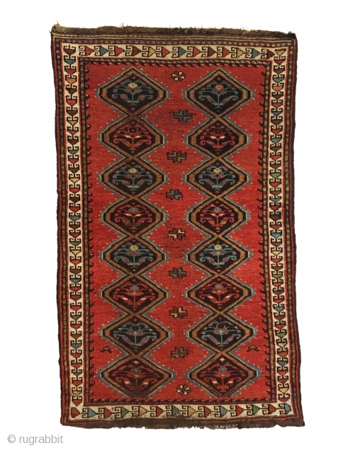 Antique Persian Veramin Rug. Late 19th Century. This piece features a repeating diamond pattern enclosing alternating shrub flowers on a saturated cherry red field. Featuring a central row of multi-colored secondary motifs.  ...